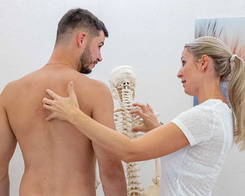 Osteopathin Martina Krenn behandelt einen Patienten im Bereich der Brustwirbelsäule - [Foto © der Botagraph]